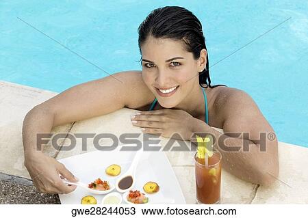 High angle view of a young woman eating food View Large Photo Image Stock Image - High angle view of a young woman eating food. Fotosearch