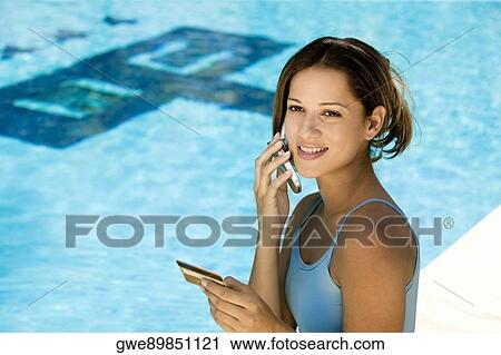 Stock Image - High angle view of a young woman talking on a mobile phone. Fotosearch