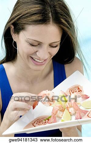 High angle view of a young woman holding food in a tray View Large Photo Image Stock Image - High angle view of a young woman holding food in a tray. Fotosearch