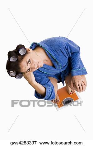 High angle view of a young woman crouching on a weight scale View Large Photo Image Stock Photo - High angle view of a young woman crouching on a weight scale. Fotosearch