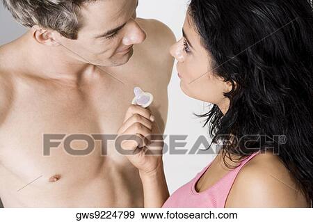 High angle view of a young woman showing a condom to a mid adult man View Large Photo Image Stock Photo - High angle view of a young woman showing a condom to a mid adult man. Fotosearch