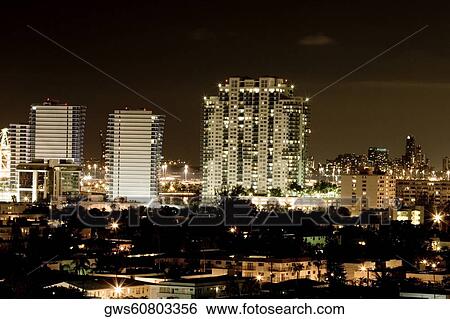 Stock Photograph - High angle view of buildings in a city lit up at night. Fotosearch