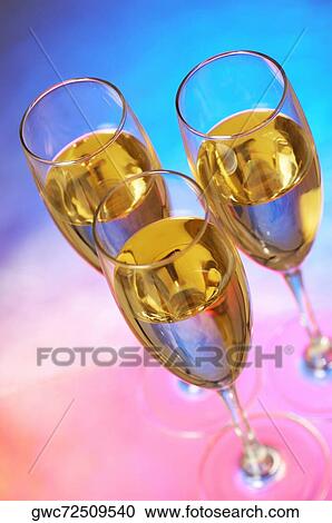 Stock Image - High angle view of champagne in three champagne flutes. Fotosearch
