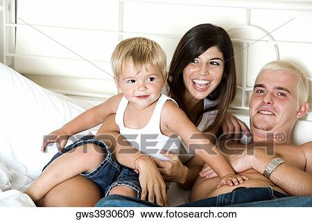 High angle view of parents lying on the bed with their son View Large Photo Image Stock Photo - High angle view of parents lying on the bed with their son. Fotosearch