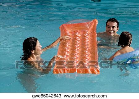 High angle view of parents with their daughter in a swimming pool View Large Photo Image Stock Image - High angle view of parents with their daughter in a swimming pool. Fotosearch
