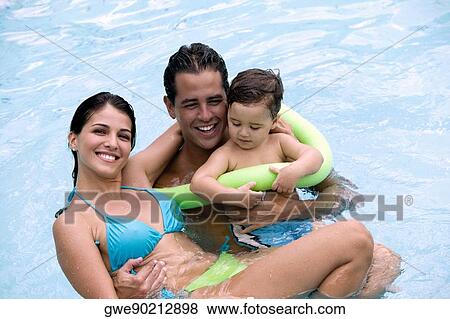 Stock Photo - High angle view of parents with their son in a swimming pool. Fotosearch