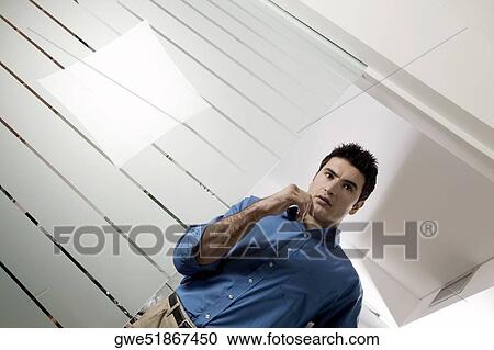 Low angle view of a businessman thinking View Large Photo Image Stock Image - Low angle view of a businessman thinking. Fotosearch