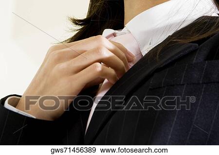 Low angle view of a businesswoman adjusting her tie View Large Photo Image Stock Photo - Low angle view of a businesswoman adjusting her tie. Fotosearch