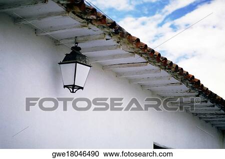 Stock Image - Low angle view of a lantern hanging from eaves. Fotosearch