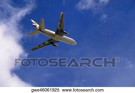 Low angle view of an airplane in flight View Large Photo Image Stock Photography - Low angle view of an airplane in flight. Fotosearch