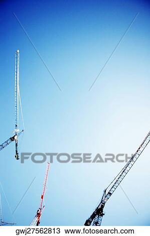 Stock Image - Low angle view of three cranes against the sky, Washington DC, USA. Fotosearch
