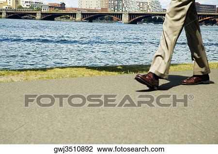 Low section view of a person walking View Large Photo Image Stock Image - Low section view of a person walking. Fotosearch