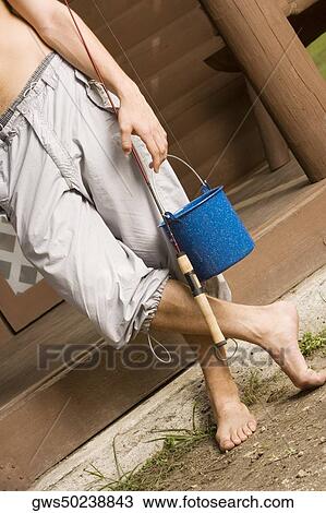 Low section view of a young man holding a fishing rod View Large Photo Image Stock Image - Low section view of a young man holding a fishing rod. Fotosearch