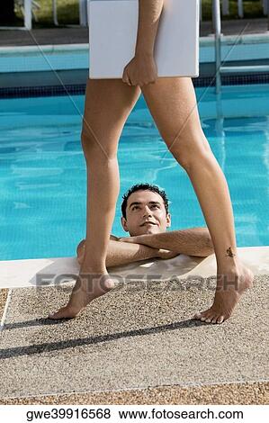 Low section view of a young woman carrying a laptop with a young man looking at her in a swimming pool View Large Photo Image Stock Photo - Low section view of a young woman carrying a laptop with a young man looking at her in a swimming pool. Fotosearch