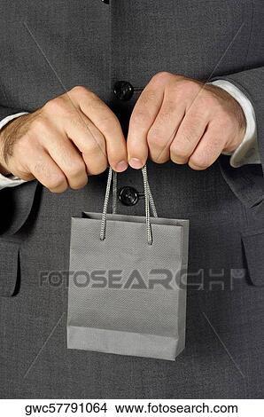 Picture - Mid section view of a businessman holding a shopping bag. Fotosearch