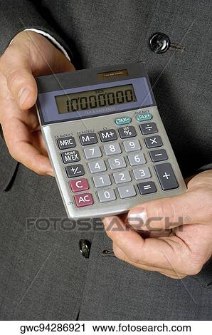 Stock Image - Mid section view of a businessman holding a calculator. Fotosearch