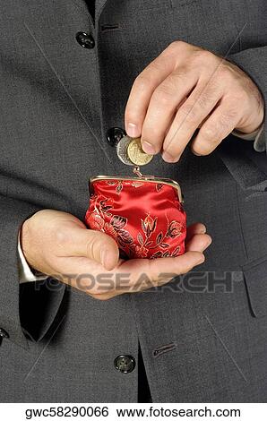 Stock Photograph - Mid section view of a businessman putting money into a change purse. Fotosearch