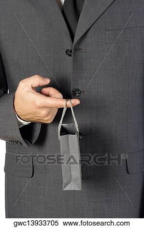 Stock Photography - Mid section view of a businessman holding a shopping bag. Fotosearch