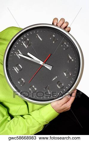 Stock Image - Mid section view of a man holding a clock. Fotosearch