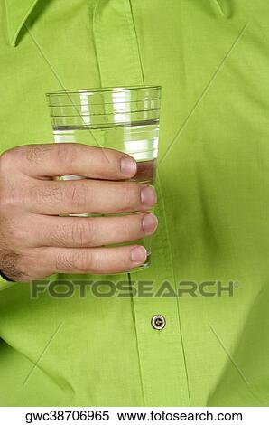 Stock Photography - Mid section view of a man holding a glass of water. Fotosearch