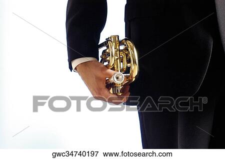 Stock Photo - Mid section view of a musician holding a trumpet. Fotosearch