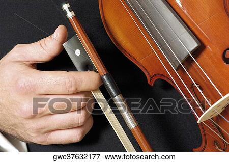 Stock Photo - Mid section view of a musician holding a violin. Fotosearch