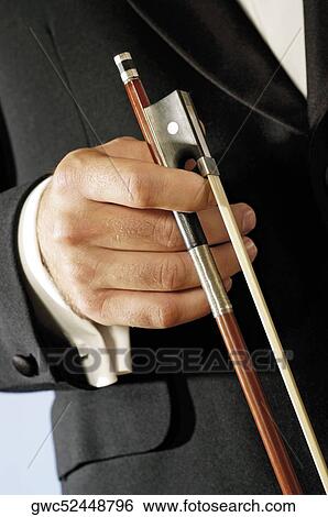 Stock Photograph - Mid section view of a musician holding the bow of a violin. Fotosearch