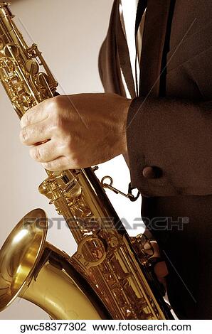 Mid section view of a musician playing the saxophone View Large Photo Image Stock Image - Mid section view of a musician playing the saxophone. Fotosearch