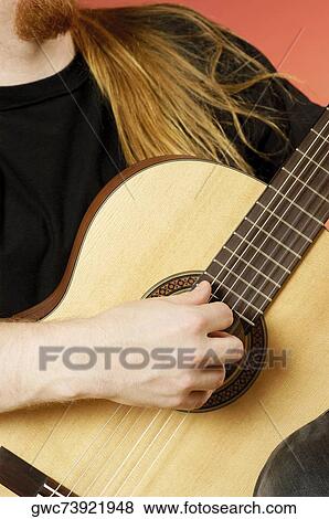 Mid section view of a musician playing an acoustic guitar View Large Photo Image Stock Photo - Mid section view of a musician playing an acoustic guitar. Fotosearch