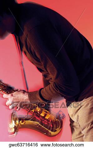 Mid section view of a musician playing the saxophone View Large Photo Image Stock Photograph - Mid section view of a musician playing the saxophone. Fotosearch