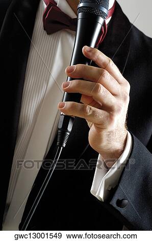 Mid section view of a singer holding a microphone View Large Photo Image Stock Photo - Mid section view of a singer holding a microphone. Fotosearch