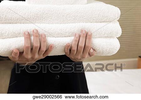Mid section view of a waitress holding a stack of towels View Large Photo Image Stock Photograph - Mid section view of a waitress holding a stack of towels. Fotosearch