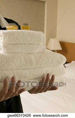 Mid section view of a waitress holding a stack of towels View Large Photo Image Stock Photograph - Mid section view of a waitress holding a stack of towels. Fotosearch
