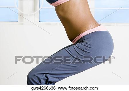 Mid section view of a young woman exercising View Large Photo Image Stock Photograph - Mid section view of a young woman exercising. Fotosearch