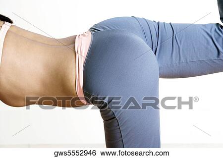 Mid section view of a young woman exercising View Large Photo Image Stock Photograph - Mid section view of a young woman exercising. Fotosearch