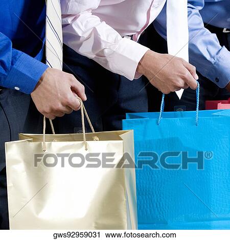 Mid section view of three businessmen holding shopping bags View Large Photo Image Stock Image - Mid section view of three businessmen holding shopping bags. Fotosearch