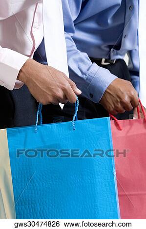 Mid section view of two businessmen holding shopping bags View Large Photo Image Stock Photograph - Mid section view of two businessmen holding shopping bags. Fotosearch