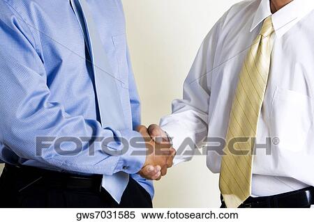 Mid section view of two businessmen shaking hands View Large Photo Image Stock Photography - Mid section view of two businessmen shaking hands. Fotosearch