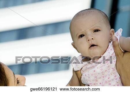 Stock Image - Mother holding up her daughter. Fotosearch