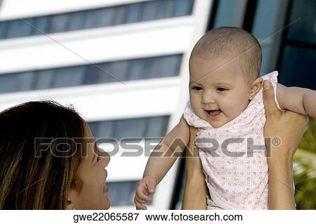 Mother holding up her daughter View Large Photo Image Stock Photo - Mother holding up her daughter. Fotosearch