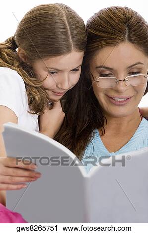 Mother reading a magazine with her daughter View Large Photo Image Stock Image - Mother reading a magazine with her daughter. Fotosearch