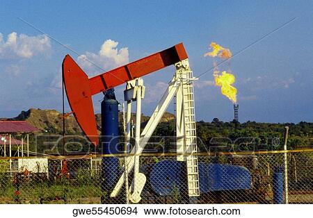 Picture - Oil rig near a chain link fence. Fotosearch
