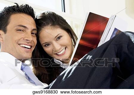 Portrait of a businessman and a businesswoman holding a magazine View Large Photo Image Stock Image - Portrait of a businessman and a businesswoman holding a magazine. Fotosearch