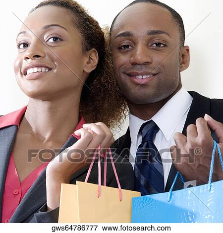 Portrait of a businessman and a businesswoman holding shopping bags View Large Photo Image Stock Photo - Portrait of a businessman and a businesswoman holding shopping bags. Fotosearch