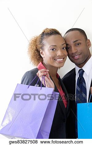 Portrait of a businessman and a businesswoman holding shopping bags View Large Photo Image Stock Photo - Portrait of a businessman and a businesswoman holding shopping bags. Fotosearch