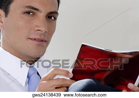 Portrait of a businessman holding a magazine View Large Photo Image Stock Photo - Portrait of a businessman holding a magazine. Fotosearch
