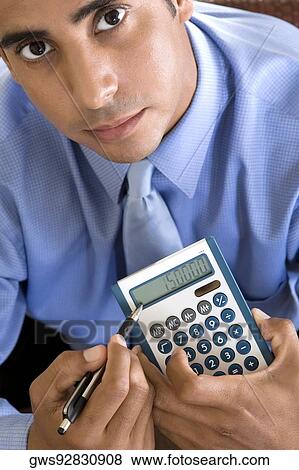 Portrait of a businessman holding a calculator and a pen View Large Photo Image Stock Photo - Portrait of a businessman holding a calculator and a pen. Fotosearch