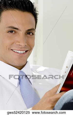 Portrait of a businessman holding a magazine View Large Photo Image Stock Photography - Portrait of a businessman holding a magazine. Fotosearch