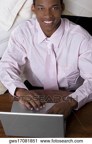 Portrait of a businessman in front of a laptop View Large Photo Image Stock Image - Portrait of a businessman in front of a laptop. Fotosearch