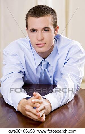 Portrait of a businessman leaning on a table View Large Photo Image Stock Photo - Portrait of a businessman leaning on a table. Fotosearch